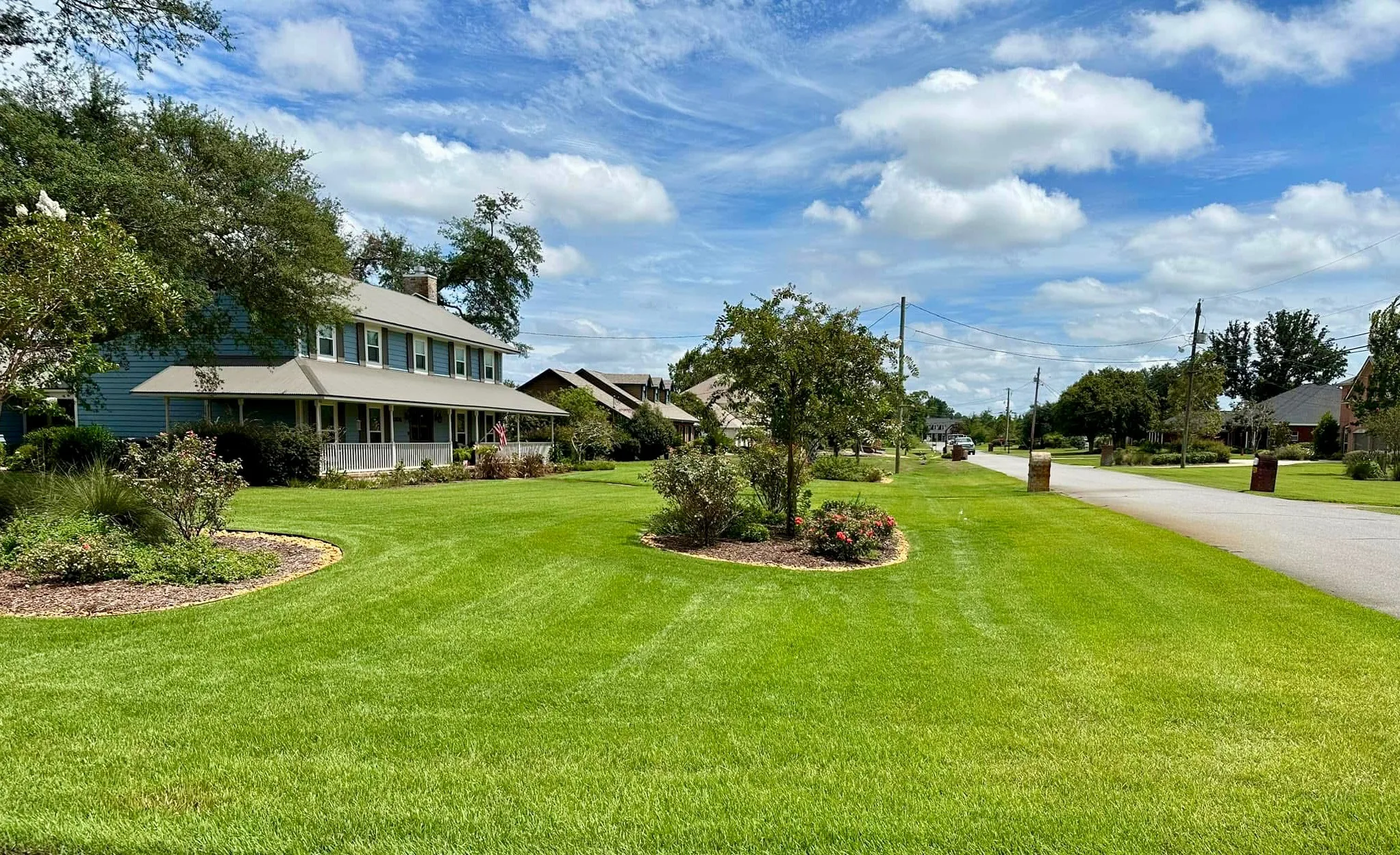 A lush green lawn and well-maintained homes in Panama City, FL. Ideal for lawn care services to enhance outdoor beauty.